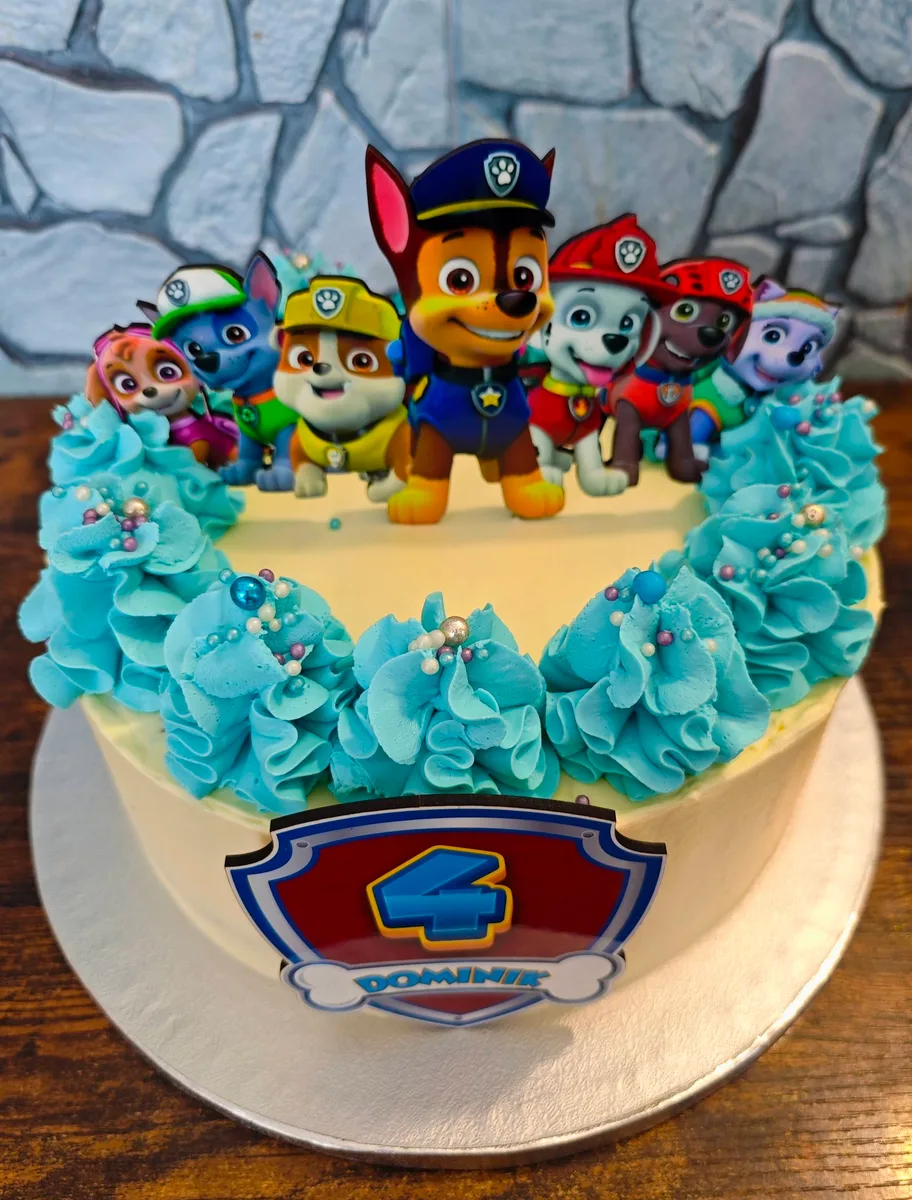 Zápichy Paw Patrol na dortu s modrou dekorací.