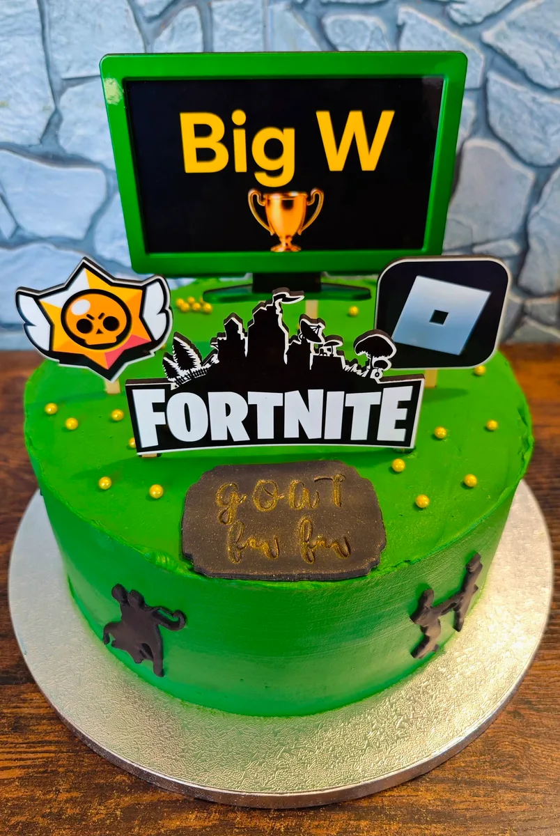 Zápichy do dortu s motivem Fortnite, včetně trofeje a postaviček z hry.