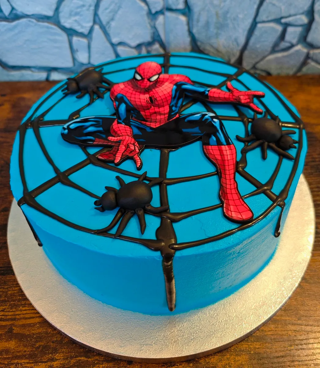 Zápich do dortu ve tvaru Spidermana v modré síti.